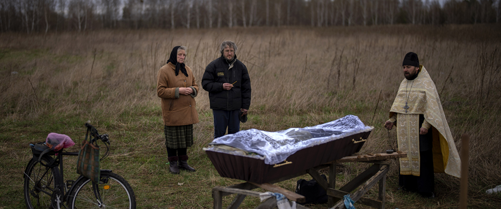 Nadiya Trubchaninova, 70, bredvid sin son Oleg Trubchaninov, 46, vid begravningen av sin sonen och brodern Vadym, 48, som dödades av ett rysk arméskott den 30 mars, Butja, Ukraina.
