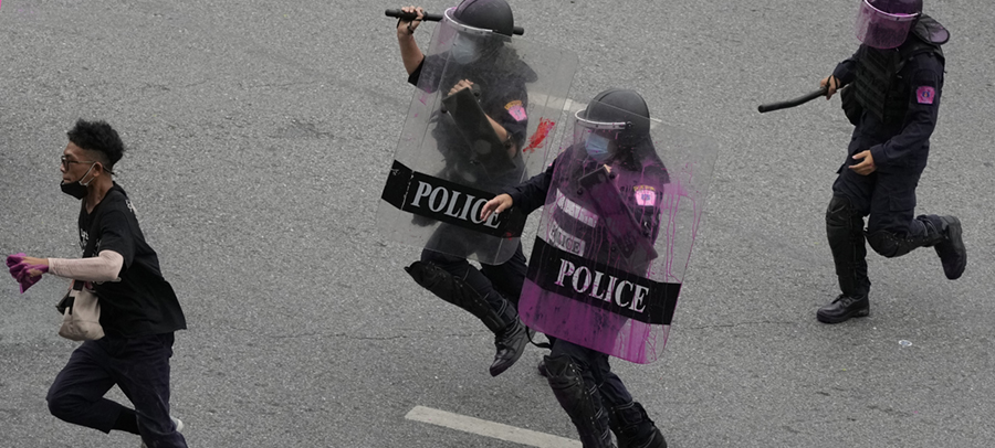 Kravallpolis jagar en regeringskritisk demonstrant under protester i Bangkok, Thailand, 11 augusti 2021.