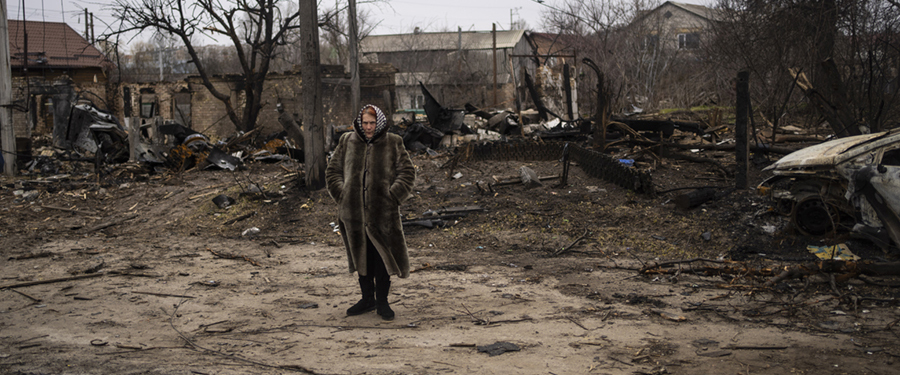 En kvinna står mitt i förstörelsen som orsakats av det ryska anfallskriget, Butja, Ukraina, tisdagen den 5 april 2022.