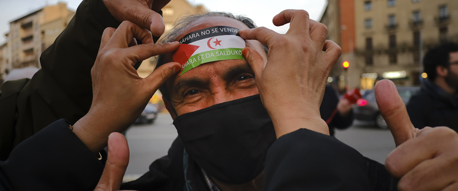 En supporter täcker sitt ansikte med ett klistermärke där det står "Free Sahara" vid en protest till stöd för Polisario Front och ett fritt Sahara, i Pamplona, norra Spanien, onsdagen den 23 mars 2022.