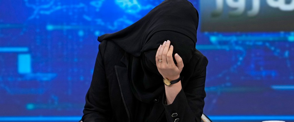 Nyhetsankaret Khatereh Ahmadi böjer sitt huvud på söndagen medan hon läser nyheter för kanalen Tolo News – sedan några dagar måste journalister täcka sina ansikten i tv-rutan.