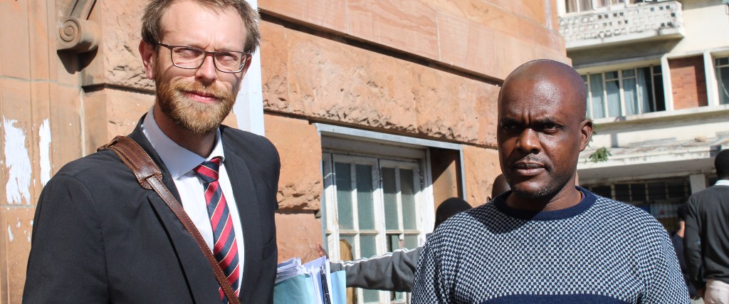 Jeffrey Moyo (till höger) med en av sina försvarare, Doug Coltart, utanför domstolen i Bulawayo.