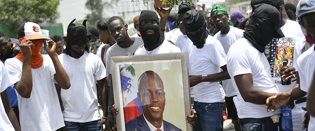 Gängmedlemmar med ett foto av den dödade presidenten Jovenel Moïse under en marsch för att krav på röttsida i mordutredningen, Port-au-Prince, Haiti, Moïse, 26 juli 2021.