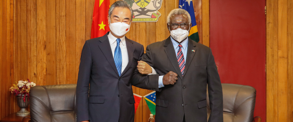 Salomonöarnas premiärminister Manasseh Sogavare gör armkrok med Kinas utrikesminister Wang Yi under den senares besök i den salomonska huvudstaden Honiara den 26 maj 2022.