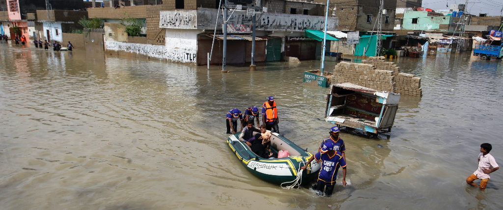 Volontärer rycker ut och transporterar strandsatta människor till följd av översvämningar i sydvästra Pakistan.