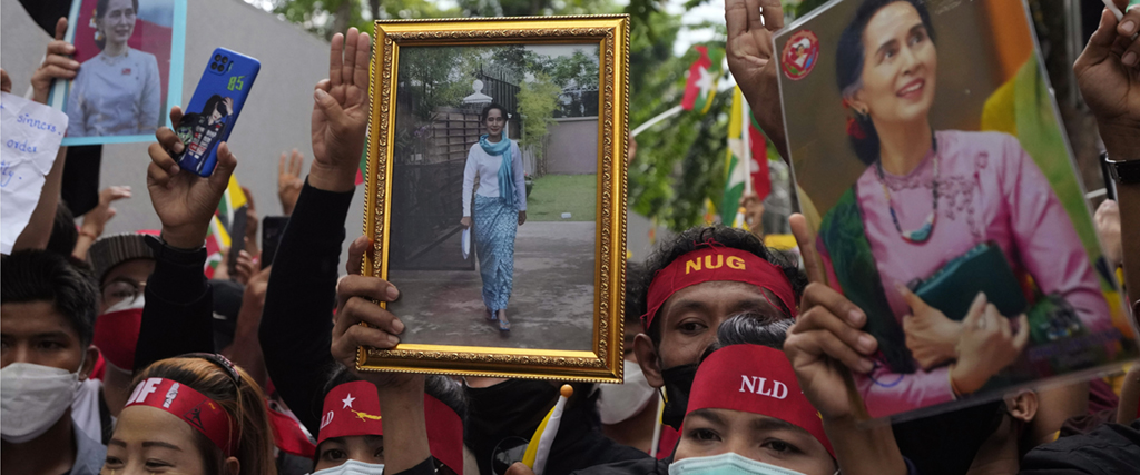 Myanmarier i Thailand håller upp bilder på den avsatta myanmariska ledaren Aung San Suu Kyi under en protest utanför Myanmars ambassad i Bangkok i juli.