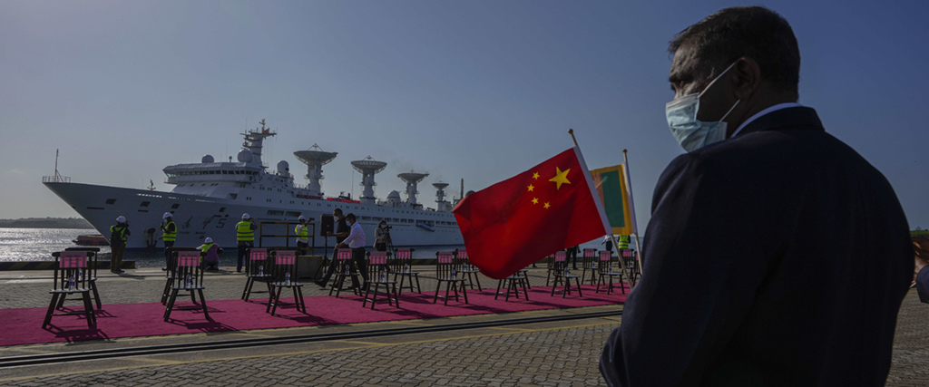 En lankesisk hamnarbetare välkomnar det kinesiska forskningsfartyget Yuan Wang 5 när det anländer till Hambantota, Sri Lanka, tisdagen den 16 augusti 2022.
