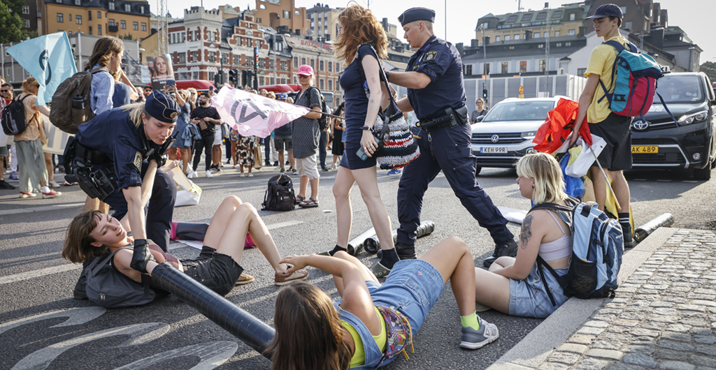 Polis på plats där klimataktivister från organisationen Extinction Rebellion har upprättat en vägspärr vid Slussen i Stockholm den 17 augusti som en manifestation för klimatet inför valet.