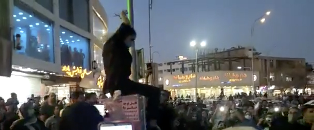 En kvinna klipper sitt hår på ett torg i centrala Kerman inför en folkmassa som skanderar ”död åt diktatorn” med hänvisning till landets högste andlige ledare Ali Khamenei.
