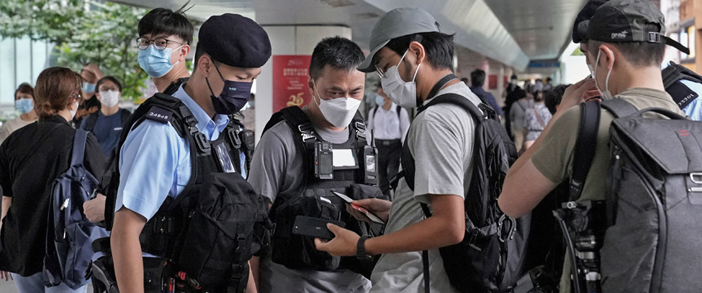 Polis i Hongkong stoppar journalister för att kontroll inför regionalt regeringsbyte i somras.