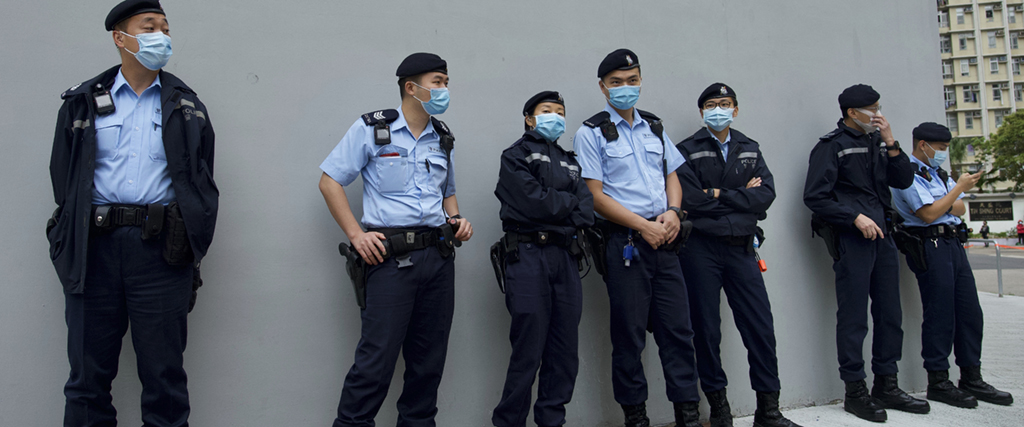Poliser vaktar utanför en polisstation i Hongkong, 22 mars 2021.