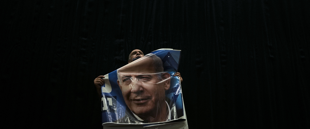 En Likud-supporter med en affisch av tidigare israeliska premiärminister Benjamin Netanyahu.