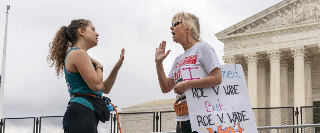 Lilo Blank, 23, från Philadelphia, vänster, som stöder aborträttigheter, och Lisa Verdonik, från Arlington, Virginia, som är anti-abort, diskuterar aborträttigheter, 13 maj 2022, Washington.