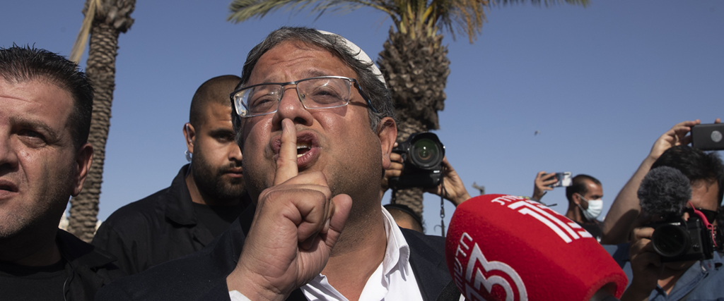 Den israeliska parlamentsledamoten Itamar Ben-Gvir som är ledare för det högerextrema partiet Otzma Yehudit (Judisk makt) tystar en palestinsk demonstrant, juni 2021.
