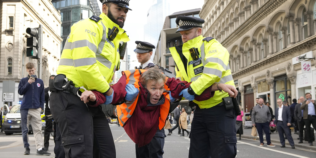 Poliser arresterar en aktivist från gruppen Just Stop Oil efter att de blockerat en väg i London, torsdagen den 27 oktober 2022, med krav på att stoppa framtida gas- och oljeprojekt från att genomföras.