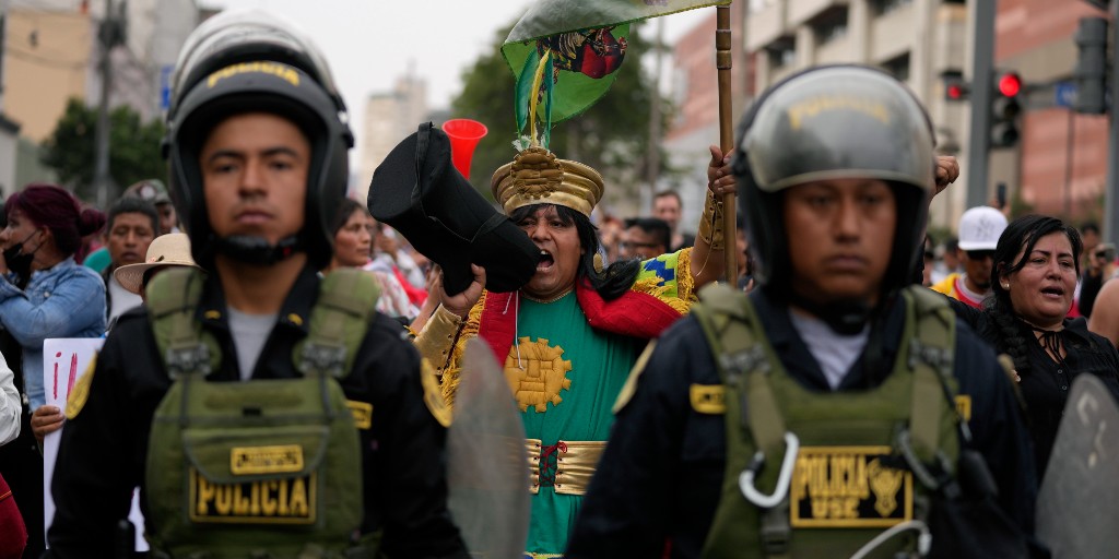 Peruansk polis eskorterar en demonstration till stöd för den avsatte presidenten Pedro Castillo.
