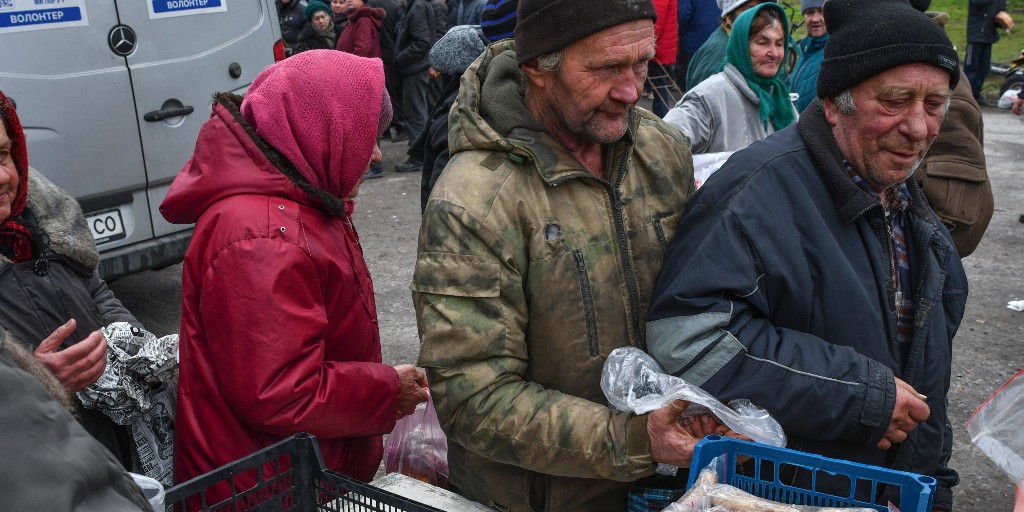 Folk tar emot mat vid i den ukrainska byn Drobysheve i Donetsk.