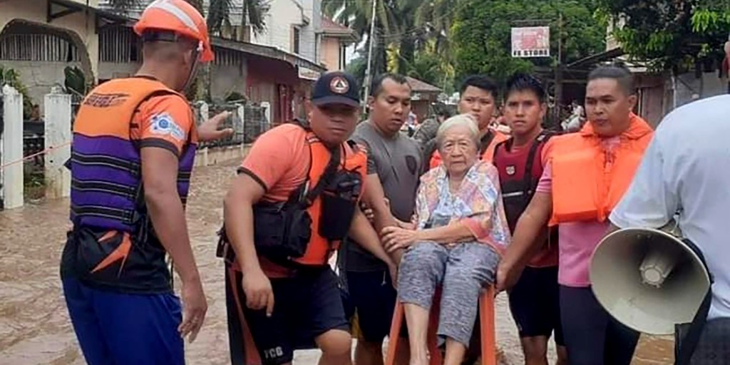 Den här bilden, som distribuerats av den filippinska kustbevakningen, visar hur räddningsarbetare bär iväg en kvinna i orten Plaridel.