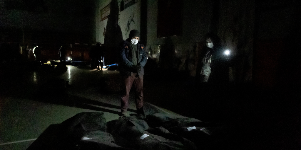 I den strömlösa gymnastiksalen i Kahramanmaras bryts mörkret endast av flackande mobiltelefonlampor.