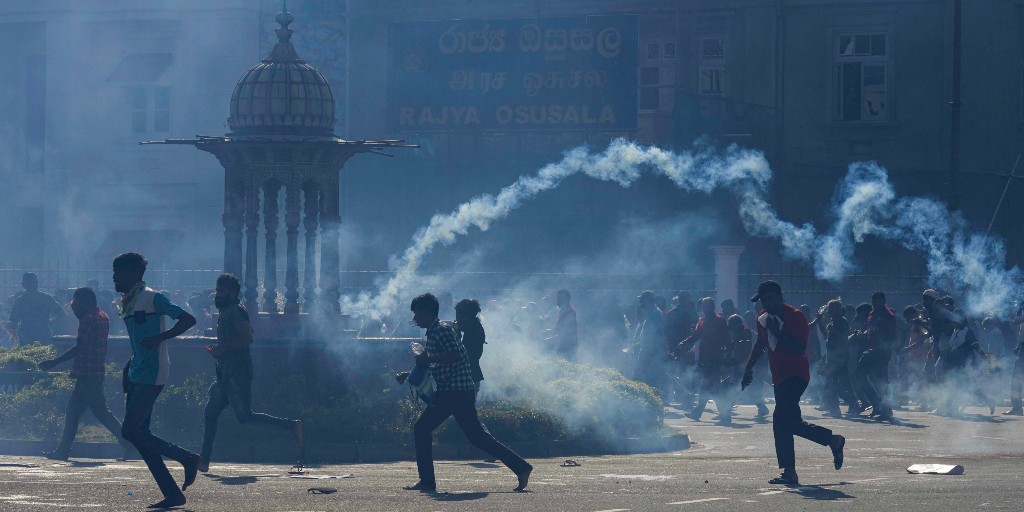 Demonstranter i Colombo flyr polisens tårgas.