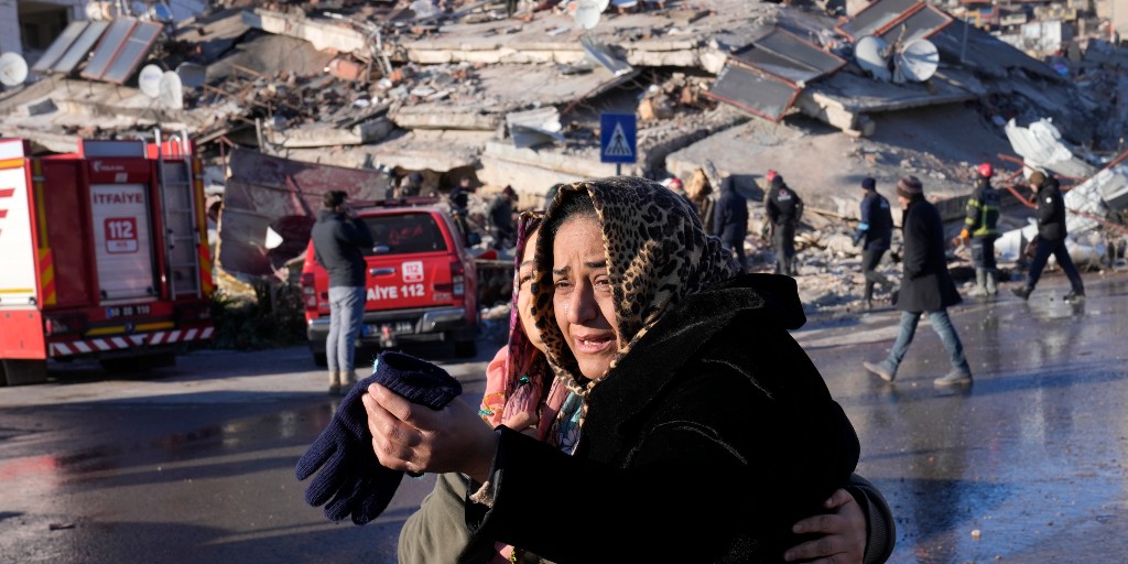 Två kvinnor gråter framför en raserad byggnad i Kahramanmaras i södra Turkiet.
