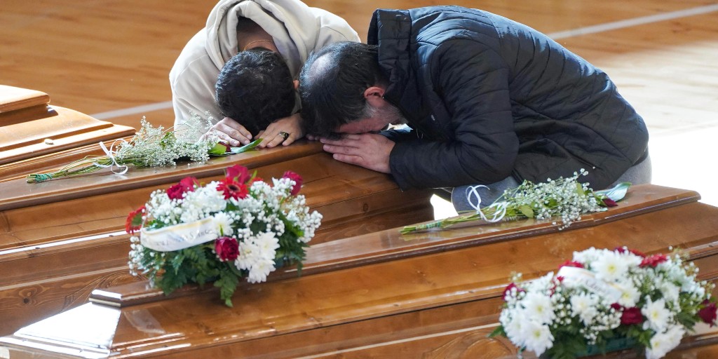 Anhöriga gråter på kistan till en anhörig som omkom i fartygsolyckan utanför Crotone i södra Italien förra helgen.