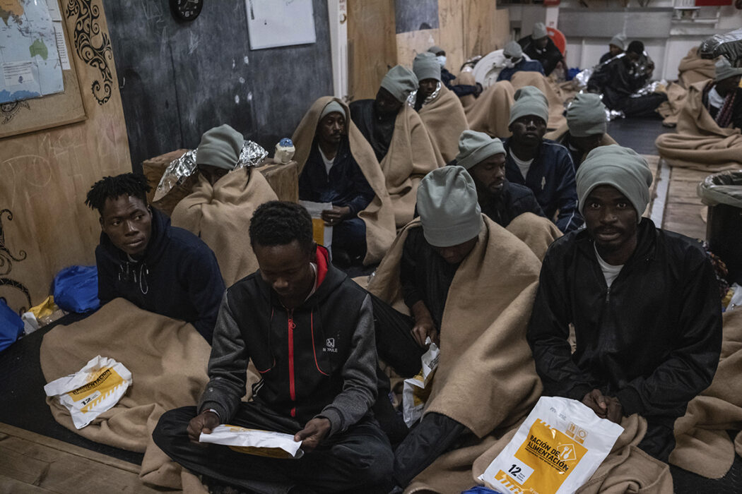 Haidar sitter med andra överlevande under matutdelning på fartyget pålandstigningen i Ancona, Italien, den 12 januari 2023