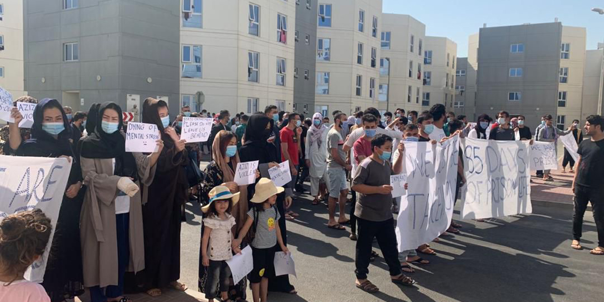 Afghaner protesterar mot sin utdragna vistelse i Emirates Humanitarian City i Abu Dhabi, 2021.