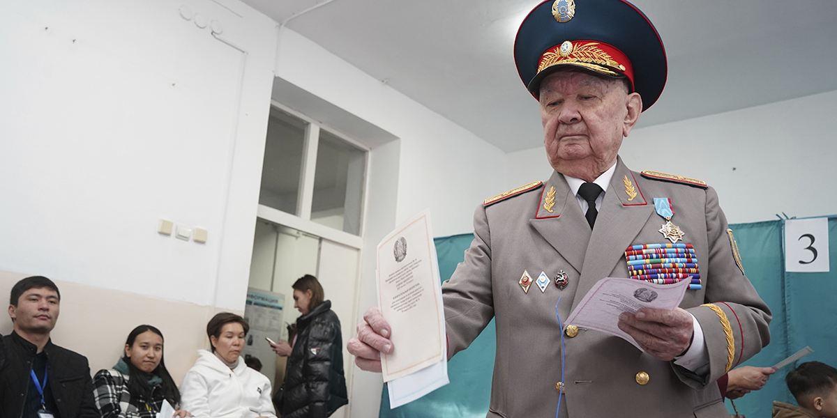 Äldre man klädd i sovjetisk arméuniform röstar vid en vallokal i Almaty, Kazakstan, söndagen den 19 mars 2023.