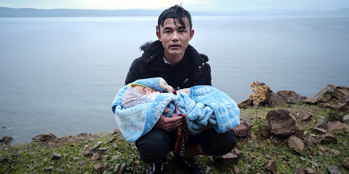 Migrant med baby på den grekiska ön Lesbos, efter att ha korsat Egeiska havet på en jolle från Turkiet.