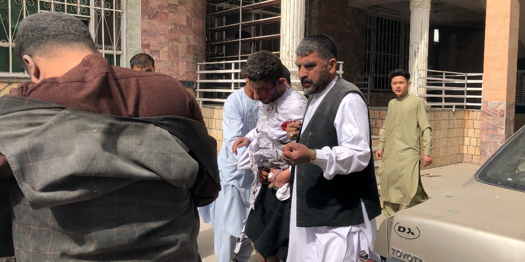 En skadad man får hjälp efter en bombattack mot en prisceremoni för journalister i Mazar-i-Sharif i Balkhprovinsen i Afghanistan på lördagsförmiddagen.