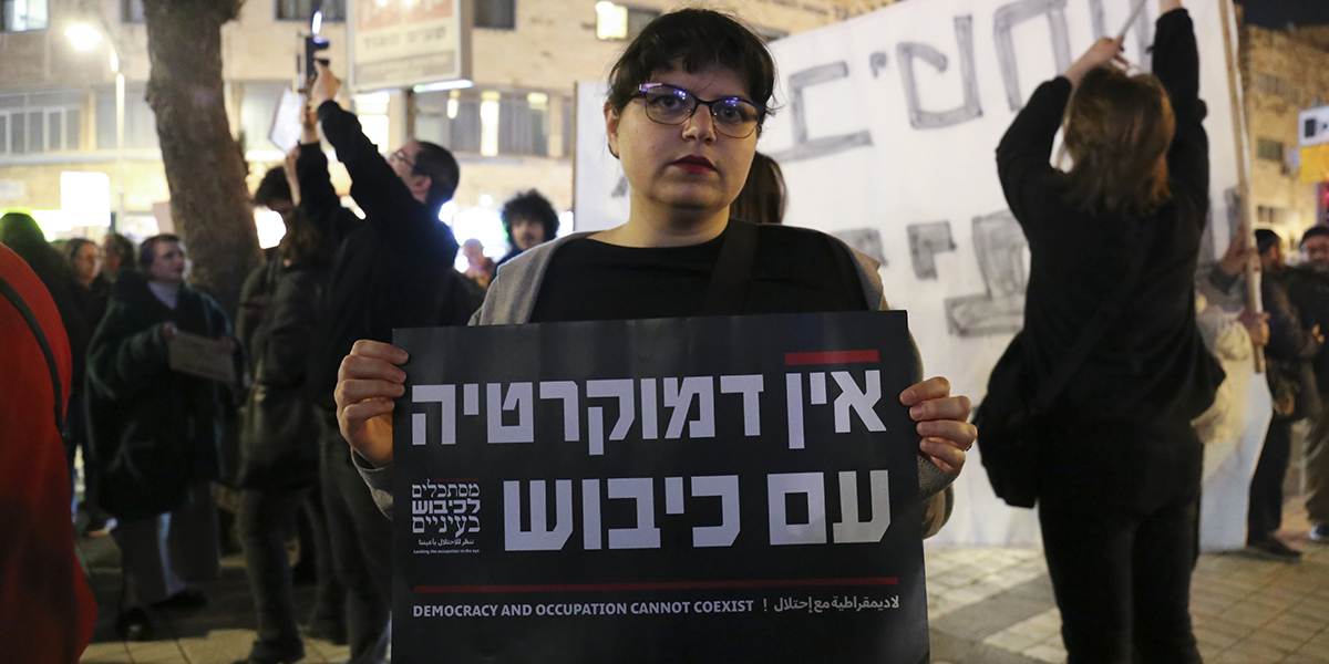 Cornelia Mikaelsson/TTJerusalembon Noa är orolig för att regeringen kommer att försämra villkoren för palestinier och håller plakatet: "Demokrati och ockupation kan inte existera samtidigt".