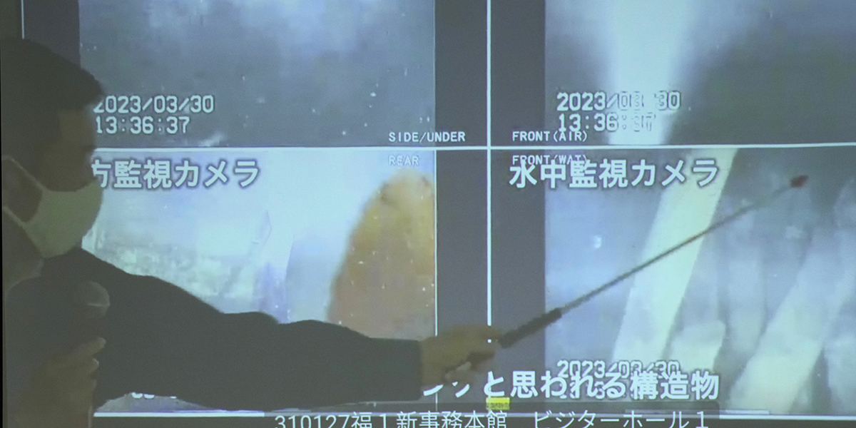 En talesperson för operatören Tepco visar de nytagna bilderna från kärnkraftverket Fukushima i Japan.