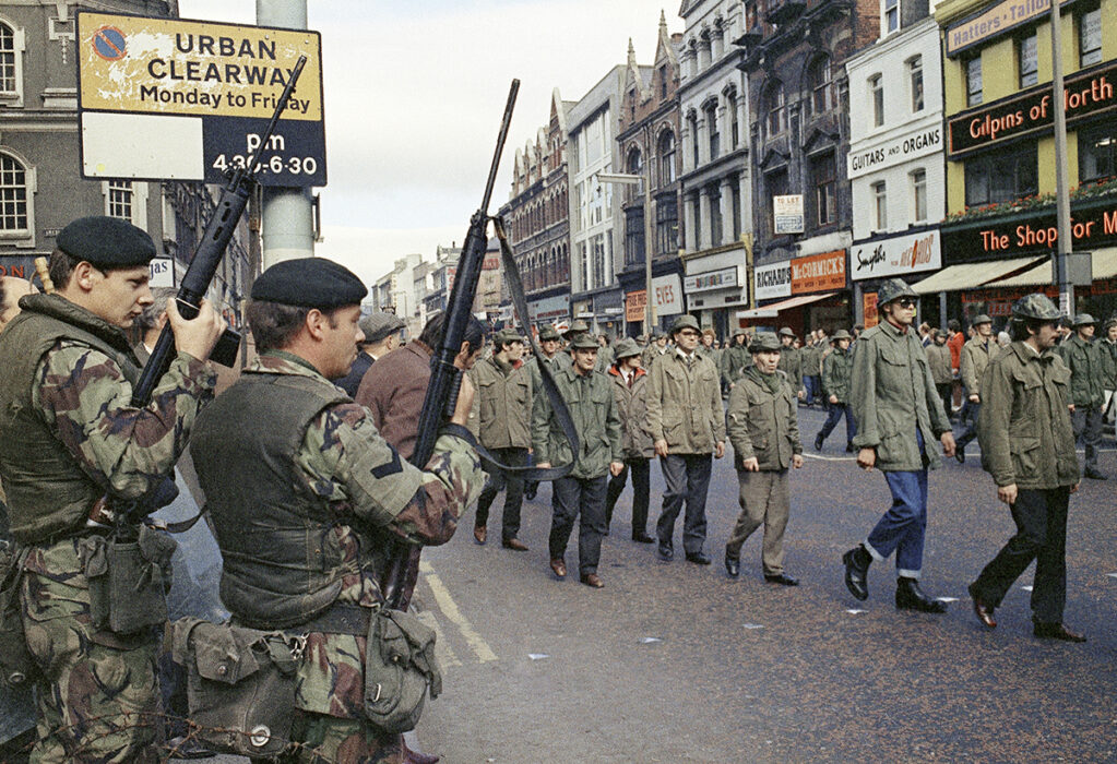 Brittiska trupper tittar på när medlemmar av Ulster Defence Association paraderar genom Belfast, Nordirland, augusti 1972