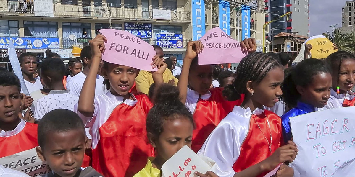 Barn håller fredsskyltar vid en gatukarneval som anordnas av Tigray Development Association till stöd för det nyligen överenskomna fredsavtalet mellan den etiopiska federala regeringen och Tigray-styrkorna i Mekele, huvudstaden i Tigray-regionen, i norra Etiopien lördagen den 26 november 2022.