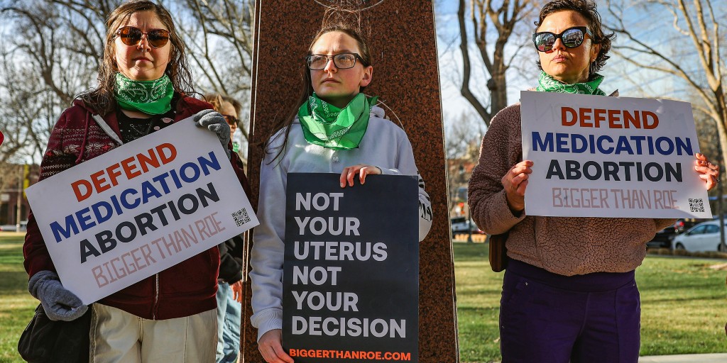 Tre medlemmar av the Women's March protesterar för rätten till abort utanför en federal domstol i Amarillo i Texas i mitten av mars 2023.