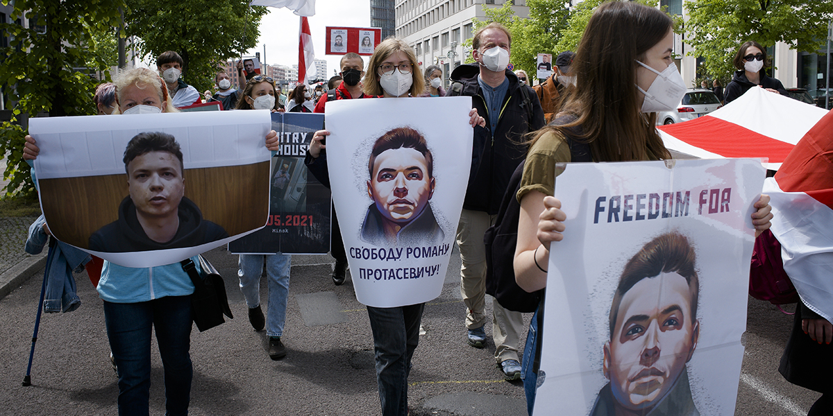 Människor bär plakat med Roman Protasevitjs bild vid en demonstration i Berlin i maj 2021.