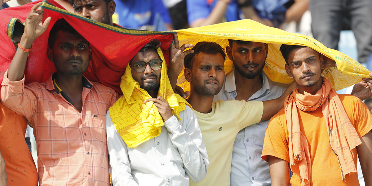 Cricketfans försöker skydda sig från värmen under en match i Lucknow i Indien den 22 april.