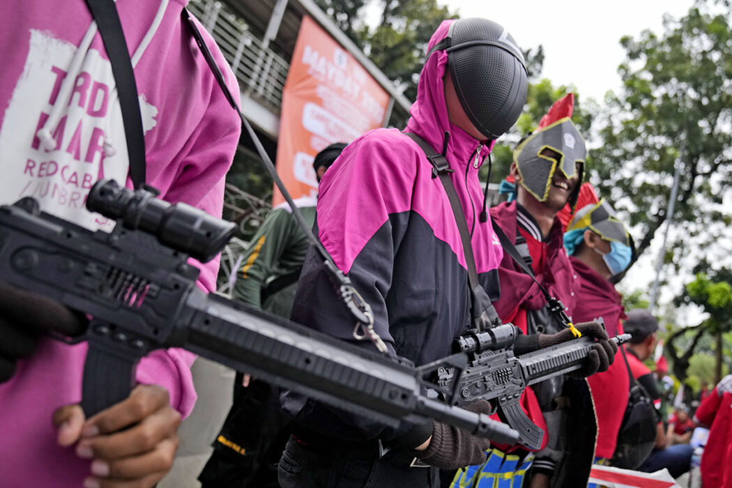 Arbetare viftar med leksaksvapen i Jakarta, Indonesien, måndagen den 1 maj 2023