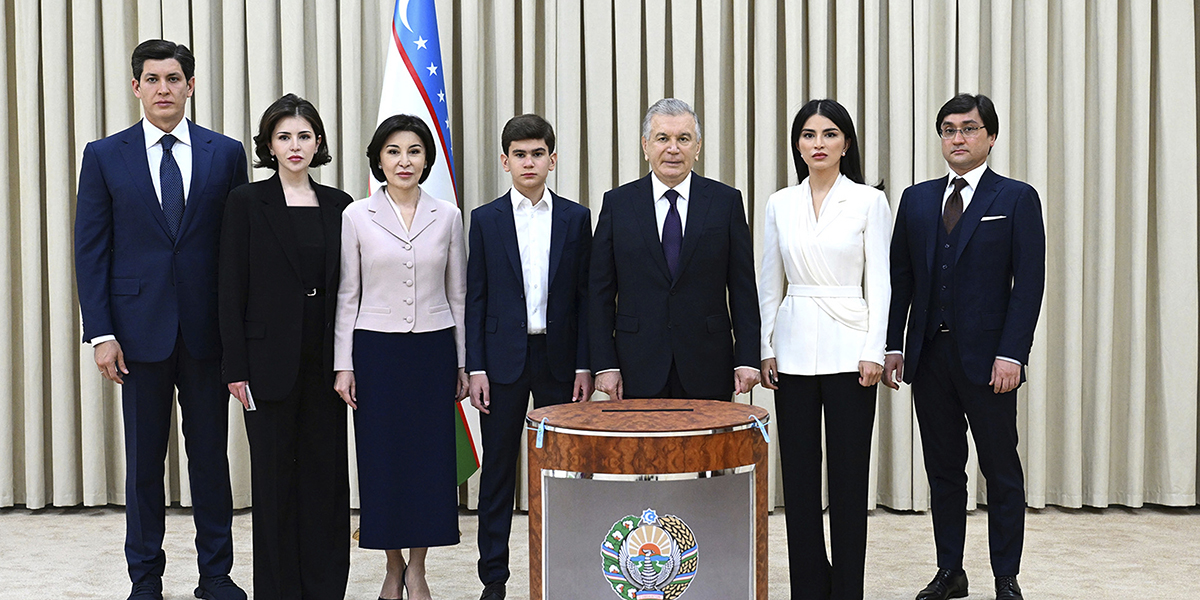 President Sjavkat Mirzijojev, tredje från höger, och hans familjemedlemmar poserar för en bild vid en vallokal i Tasjkent på söndagen.