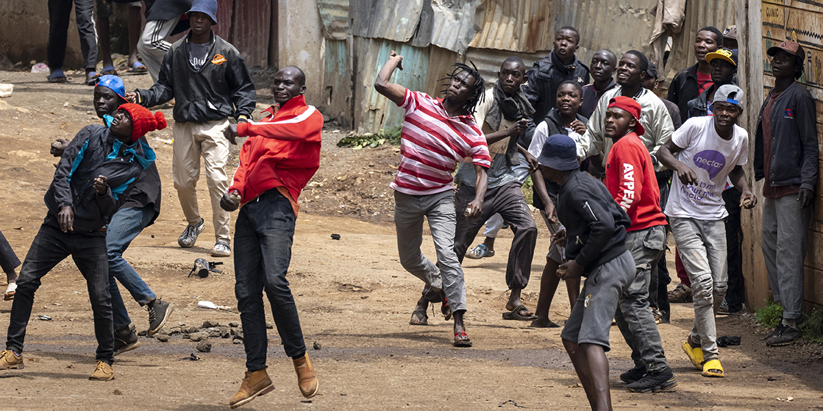 Människor kastar sten mot kravallpolis i slumområdet Kibera i Kenyas huvudstad Nairobi på tisdagen.