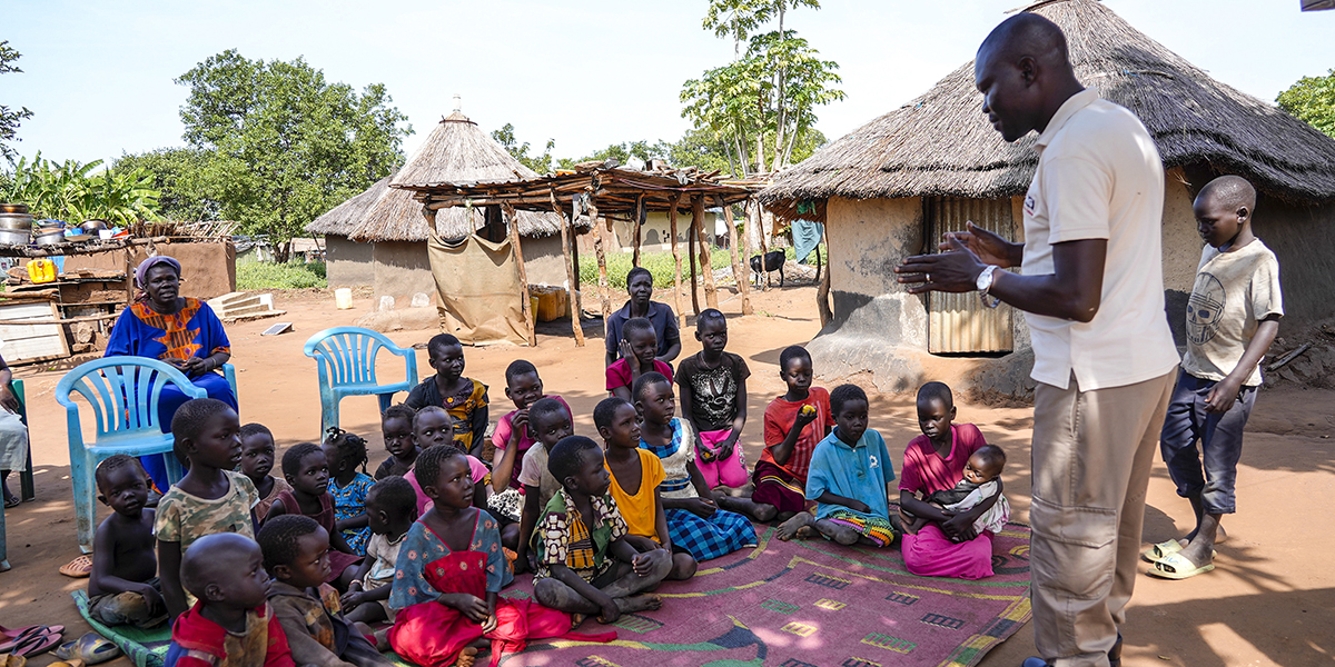 En anställd från Mines Advisory Group undervisar barn om riskerna med kjvarlämnade minor, i byn Moli i Sydsudan den 12 maj 2023.