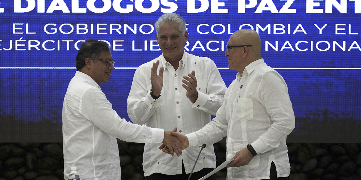  Colombias president Gustavo Petro, till vänster, och ELN-ledaren Antonio García skakar hand efter avtalet om en vapenvila, påhejade av Kubas president Miguel Díaz-Canel, i mitten.
