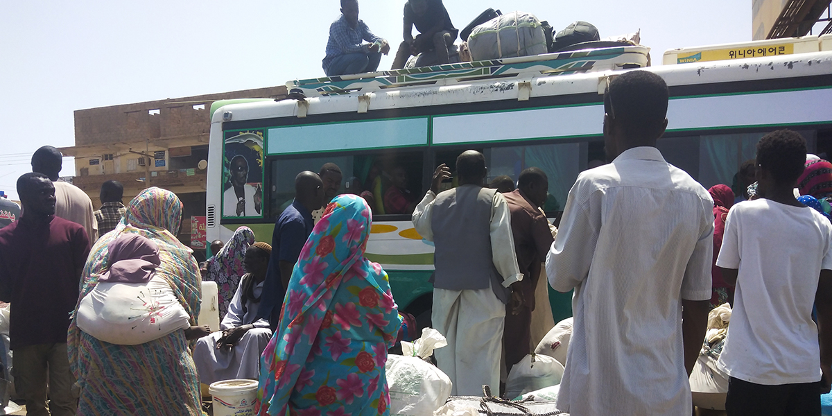 Människor väntar på en buss för att lämna Khartoum, Sudan, lördagen den 3 juni 2023, när striderna mellan Sudans armé och paramilitära Rapid Support Forces intensifierades.