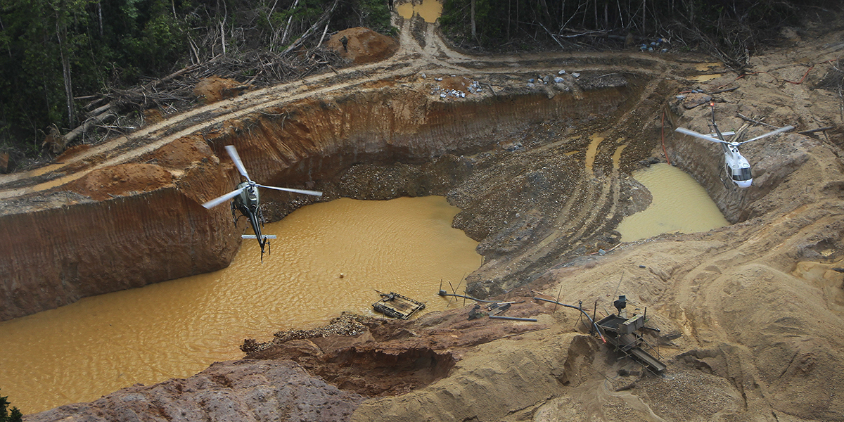 En helikopter från Miljö och Amazon-avdelningen hos den federala polisen flyger över ett illegalt gruvläger under en operation för att försöka stoppa illegal gruvdrift i urfolket Yanomamis område, delstaten Roraima, Brasilien, lördagen den 11 februari 2023.