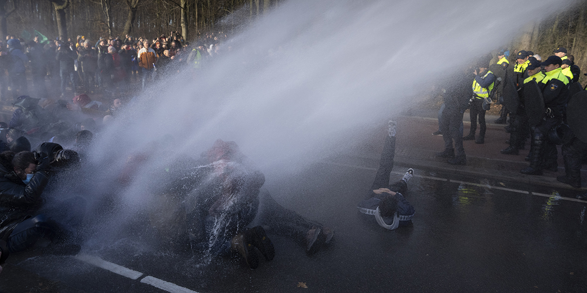 Polisen använder vattenkanon under en klimatprotest och blockad av en större motorväg av Extinction Rebellion i Haag, Nederländerna, lördagen den 11 mars 2023.