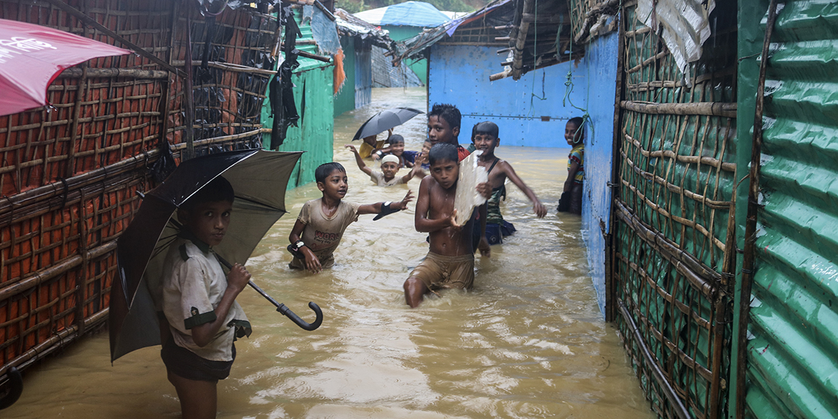 Rohingya-flyktingbarn leker i översvämningarna i flyktinglägret i Kutupalong, Bangladesh, juli 2021.