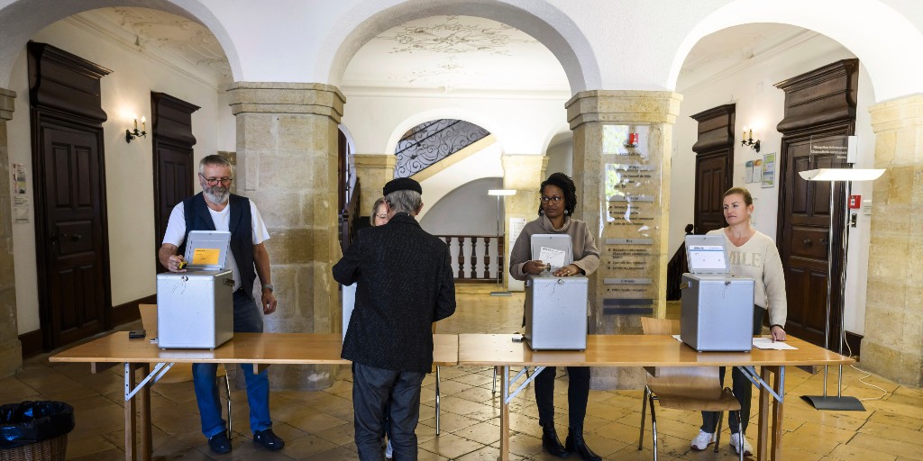 En man röstar under söndagens val i Schweiz.