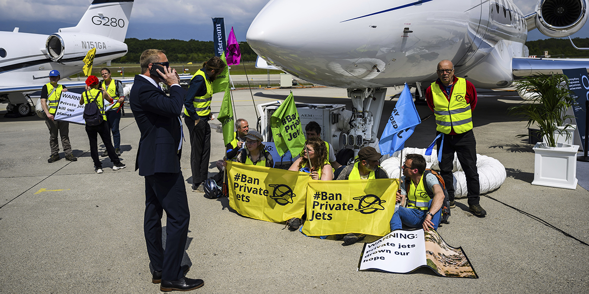 Miljöaktivister från Stay Grounded och Greenpeace blockerar flygplan vid Geneve Aeroport i Geneve, Schweiz, den 23 maj 2023.