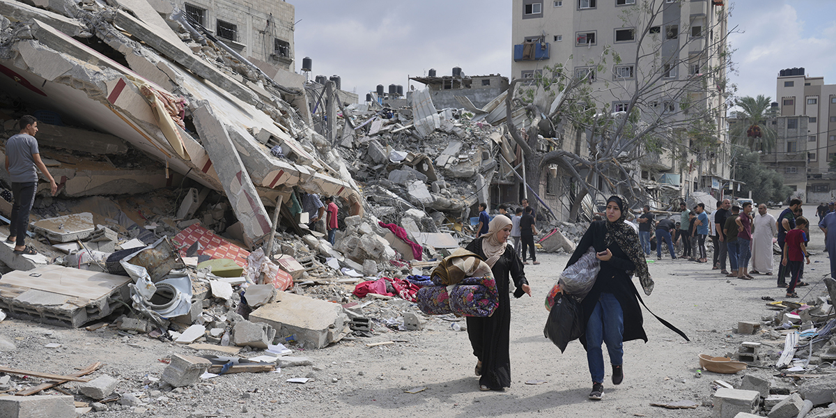 Palestinska kvinnor går förbi rester av bostadshus i Nuseirat i centrala Gaza.